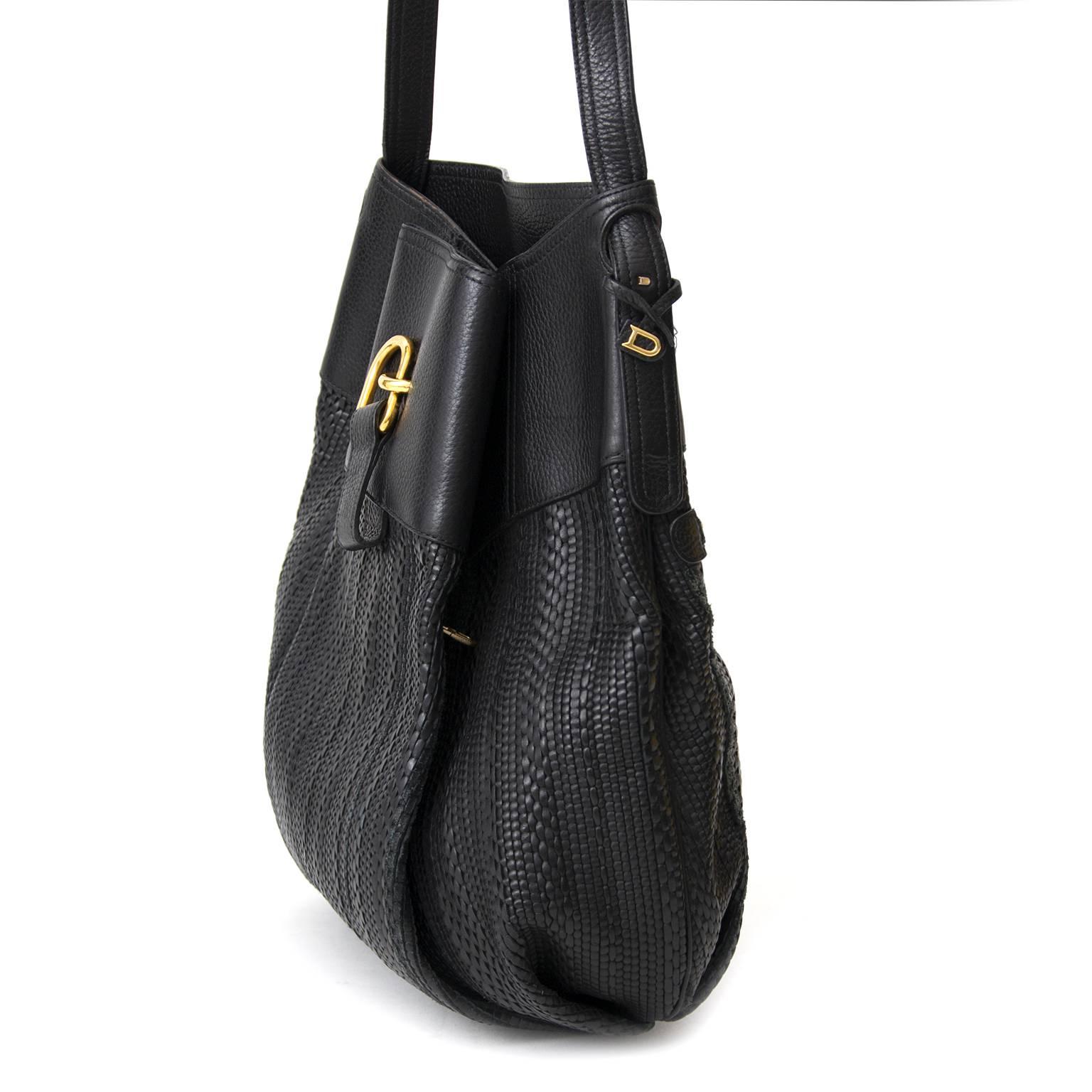 Schwarze Delvaux-Tasche aus Toile de Cuir mit goldenen Beschlägen. 

Die Oberfläche ist gewebt:: das Oberteil besteht aus Glattleder. Extra Tasche mit goldenem Reißverschluss auf der Rückseite und dezente kleine Tasche auf der Vorderseite hinter der
