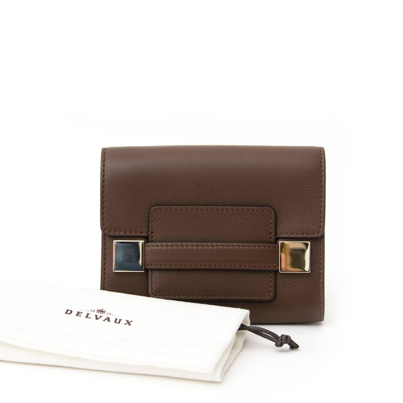 This Delvaux wallet is made out of supple and soft brown leather. The interior is lined with brown and beige leather and beige colored canvas fabric. It offers three large compartments and six smaller compartments for creditcards. The middle