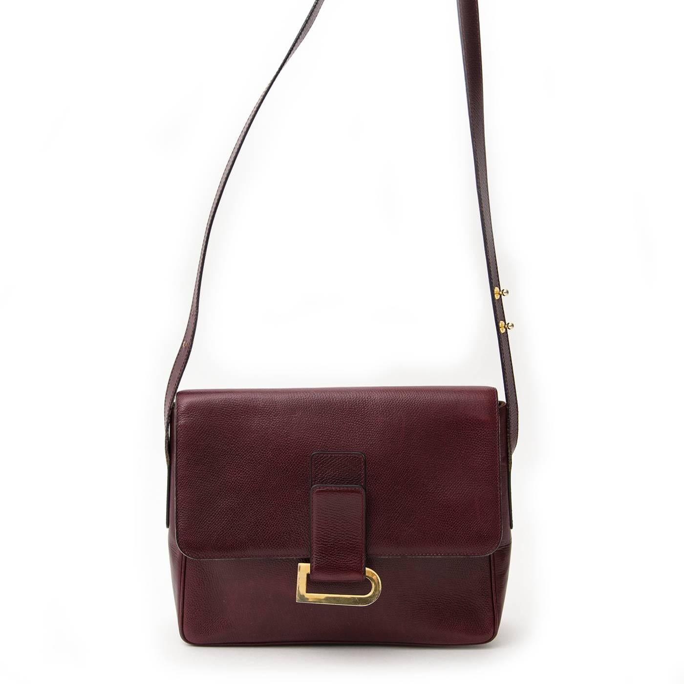 This classic Delvaux comes in an elegant burgundy colored leather and features a golden D closure. The shoulder bag has an adjustable strap and is therefore easy to wear. The front flap closes with a magnetic press button. The interior of this