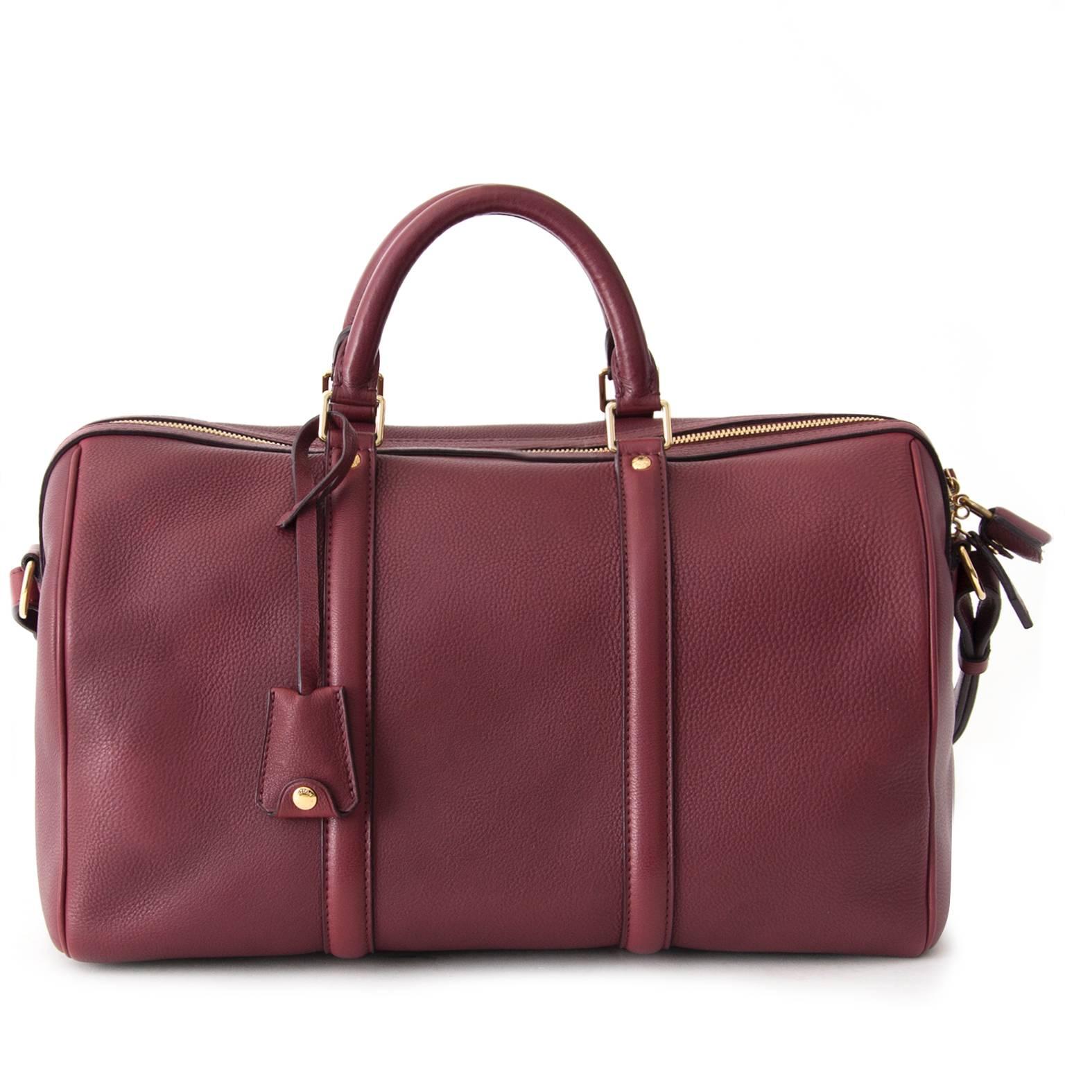 This Louis Vuitton with gold-tone hardware comes in a beautiful burgundy colored calfskin leather. 

- Leather top handle and adjustable leather strap. 
- Pad lock and key bell. 
- Closes with a top zipper. 
- Interior features suede calf