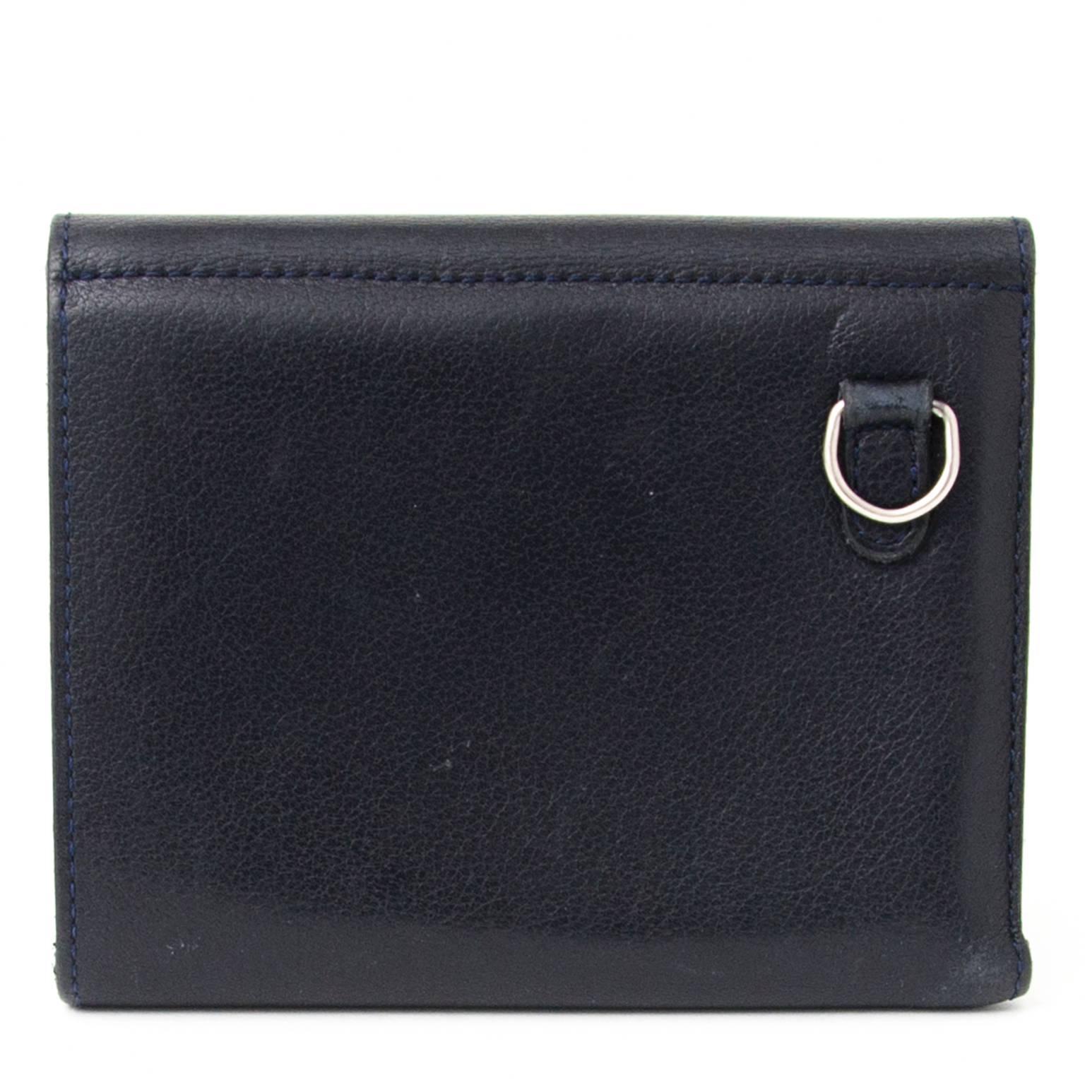 Outside is made out of leather, interior features a leather lining. 

One large compartments of which 4 for creditcards. One smaller compartment for change and coins. 

The wallet closes with a press button. 
