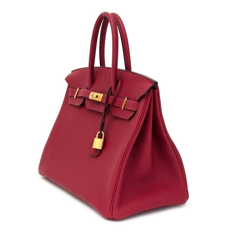 Brand new, store fresh Hermès Birkin 35 in smooth Togo leather. This iconic Hermès Birkin Rouge Grenade is one of Hermes’ newest colours, a must-have in your collection. This togo leather Birkin has a lovely warm shade of red with a slight pink