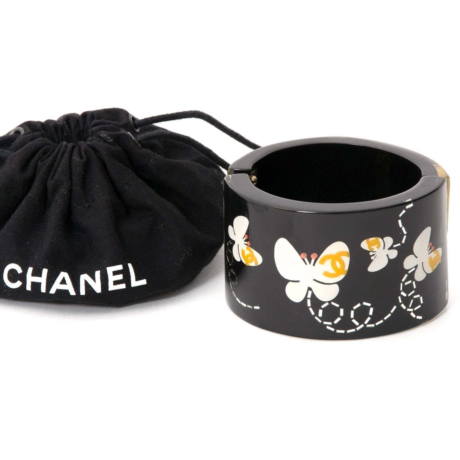 A rare Chanel cuff made of black resin with cheery butterfly and logo print. 