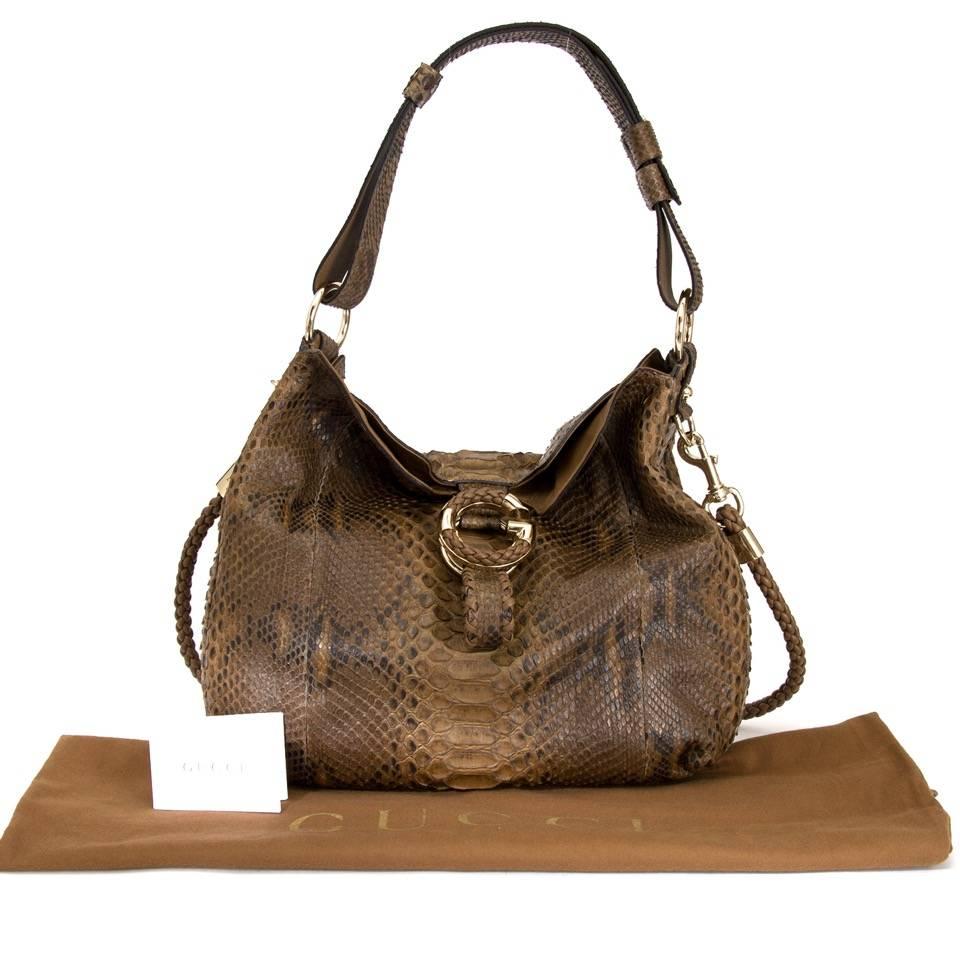 Dark brown and beige python Gucci G Wave hobo. This super-chic shoulder bag is crafted of luxurious fine python. The bag features a looping python shoulder strap and brass hardware.

This is a marvelous shoulder bag for everyday use, from Gucci!