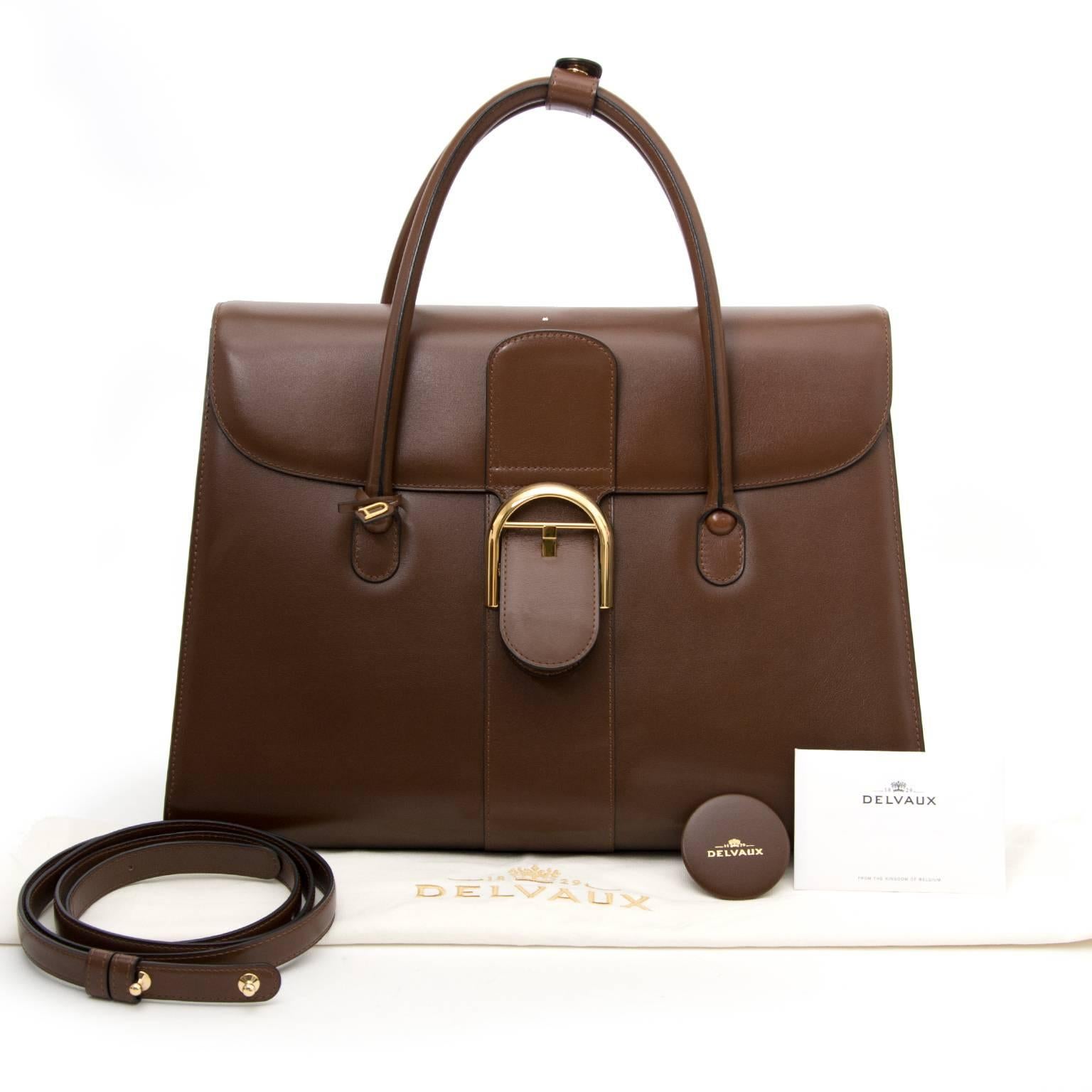 Delvaux Double Poignée Brillant bag in brown box calf leather with gold hardware. This beautiful bag is the ideal bag for work. It will add a professional look to any outfit. The bag features the iconic Brillant closure. On the inside you can find