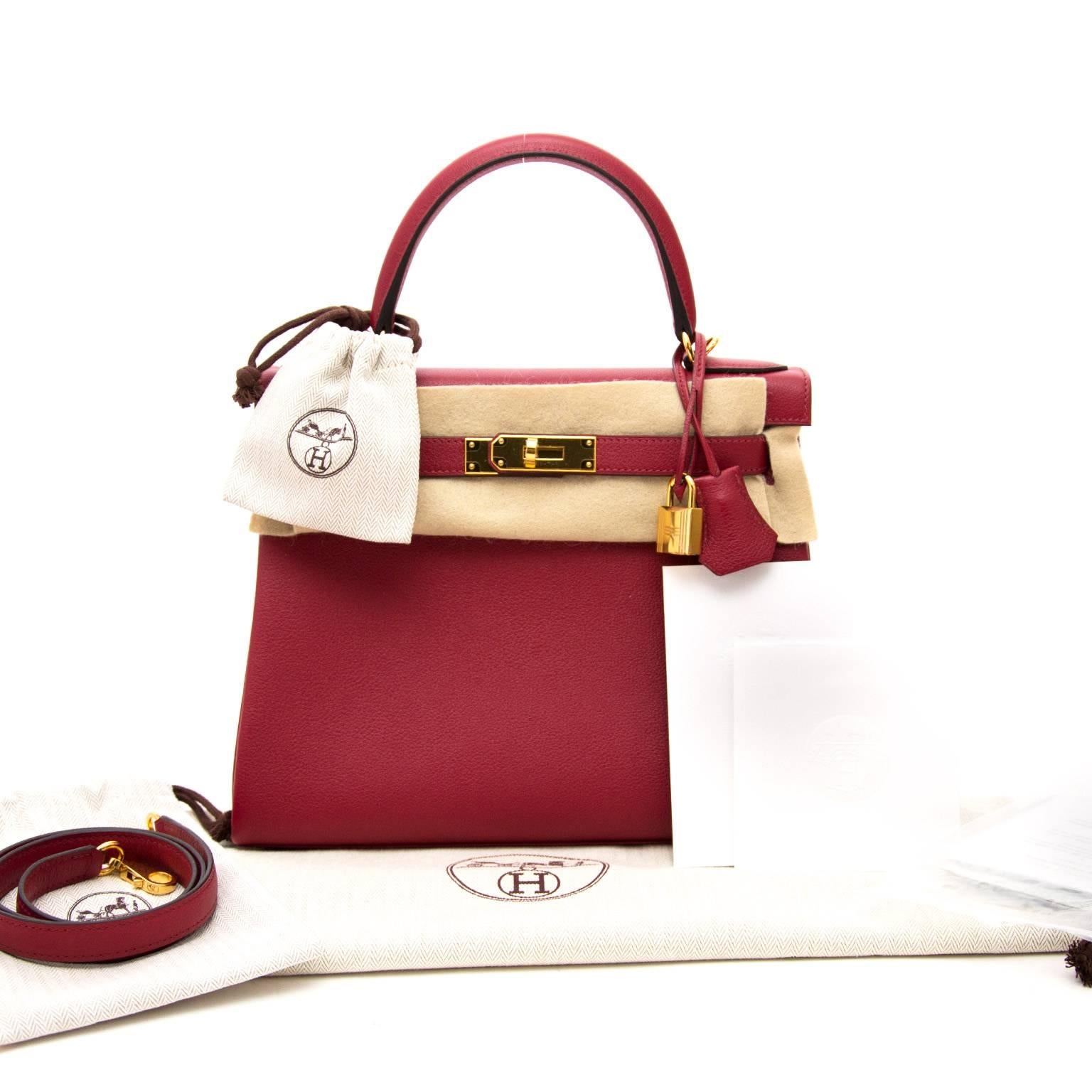 This is a brand new, storefresh Hermès Kelly Retourne 28cm Evercolor Rouge Grenat Evercolor Leather is known for it's fair firmness and it's matte texture.

The golden hardware and deep dark red color make a perfect match. Skip the
