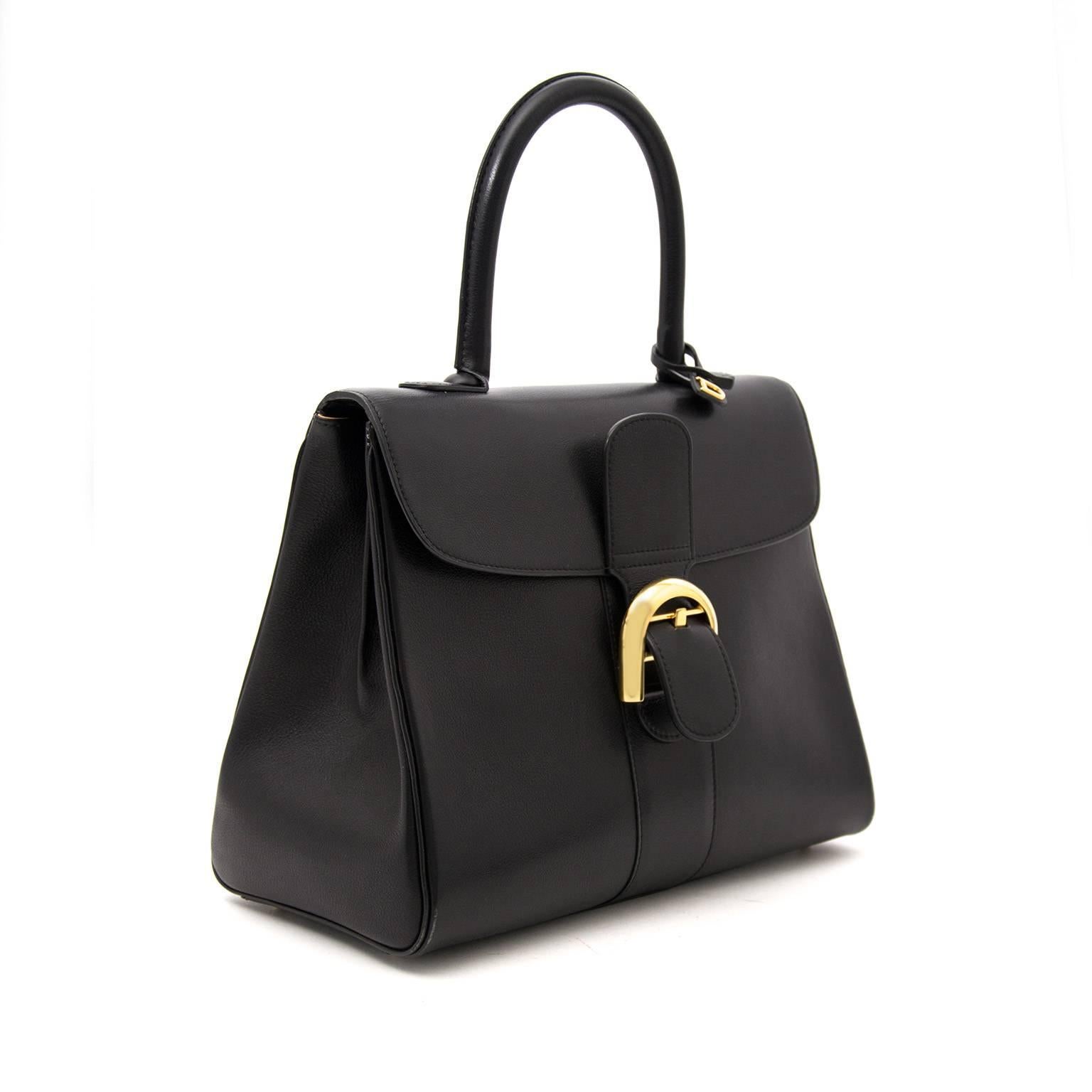 Delvaux Brillant in soft black boxcalf leather with gold hardware. The Brillant bag is known for its elegance and simplicity. 
The bag opens with the classic gold buckle to a clean beige interior with a zip pocket, side pocket and strap to attach