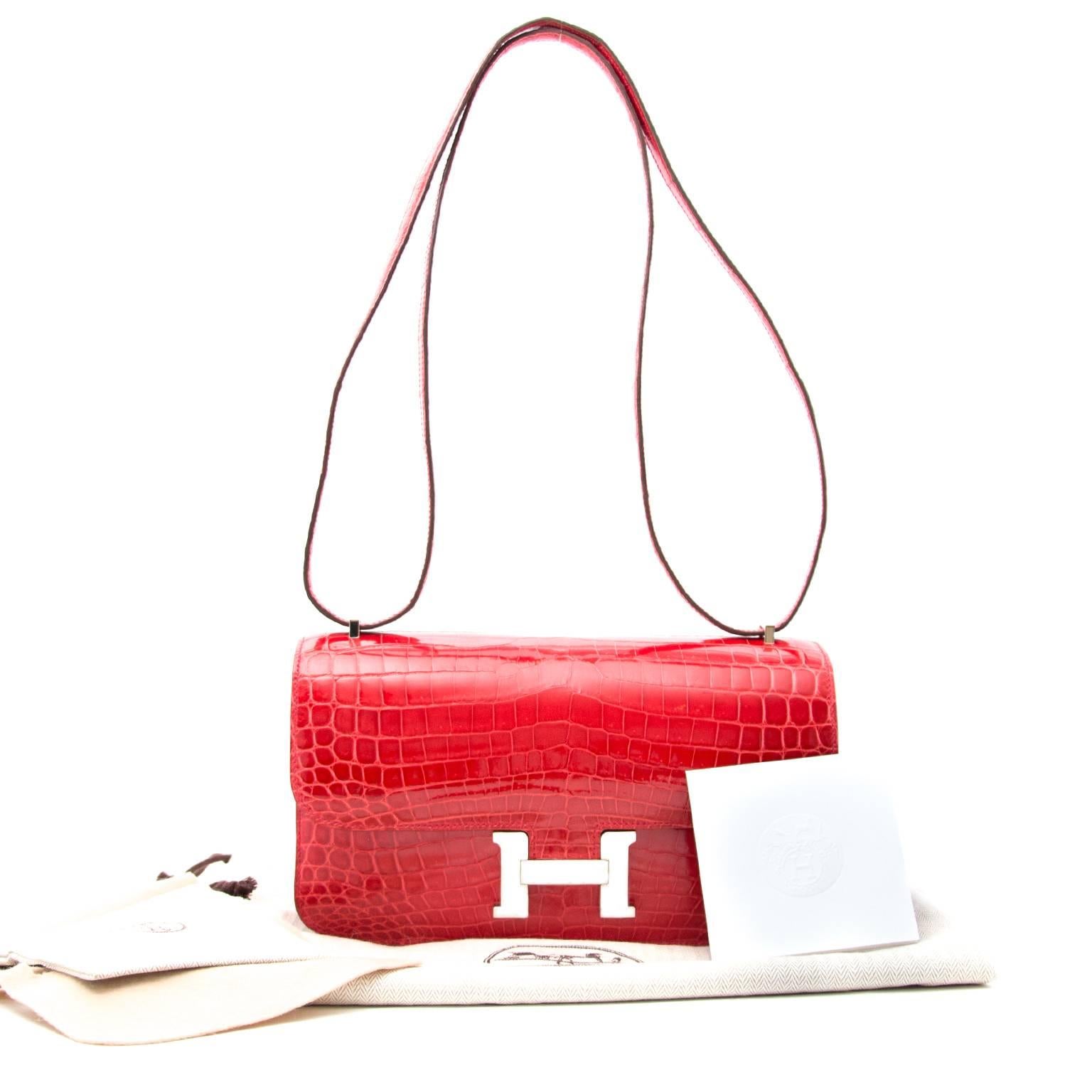 This exquisite hard to find Hermès Constance Elan bag is featured in red-toned Bougainvillier color. This bag is made from Niloticus Crocodile skin, which is identified by the dual-dot signature ( ¨ ) in the embossing and originates from the Nile