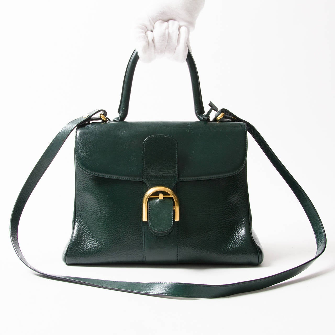 Delvaux dark green Brillant bag with gold hardware. Wear it with the shoulder strap for a more modern look. Iconic Delvaux D appliqué on top handle. Four small studs are applied on the bottom to protect this valuable bag. Delvaux logo is situated
