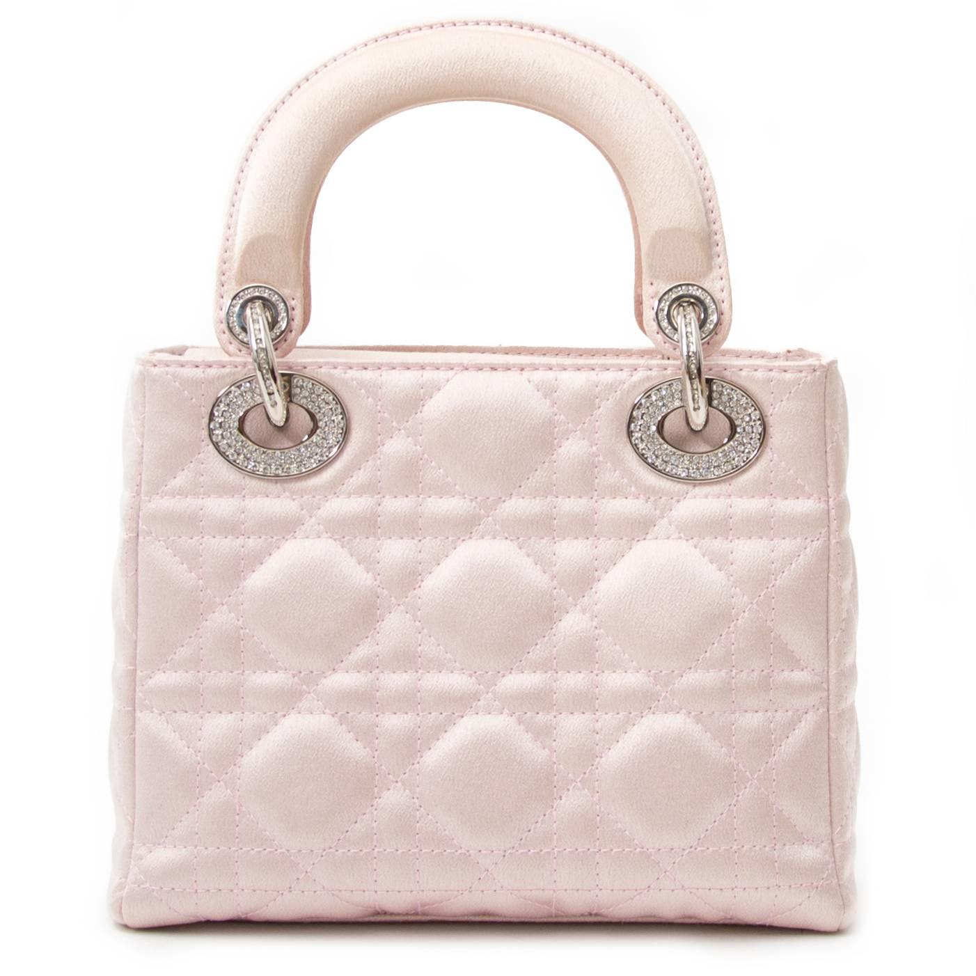 This petite Christian Dior Satin Swarovski Crystal Cannage Mini Lady Dior is a sight to be seen. The Swarovski crystal embellishments all over the hardware are divine. This bag is to be carried by hand. In good condition.