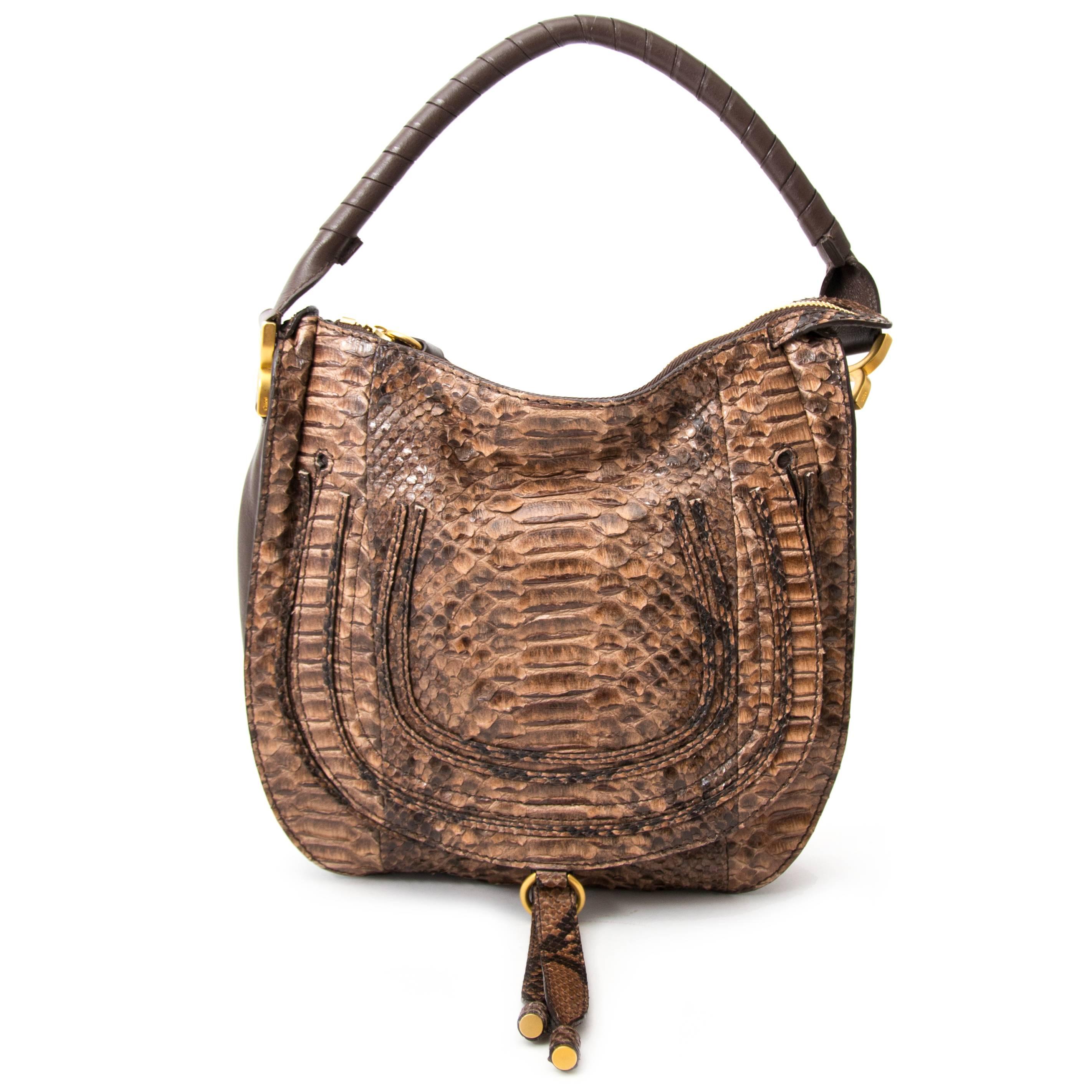 Chloé Python Marcie Satchel Bag in very good condition. This Brown Tone Chloe Marcie Shoulder Bag in exotique Python shows the brand's popular horseshoe design in a classic hobo silhouette.
Constructed from genuine brown python, this functional yet