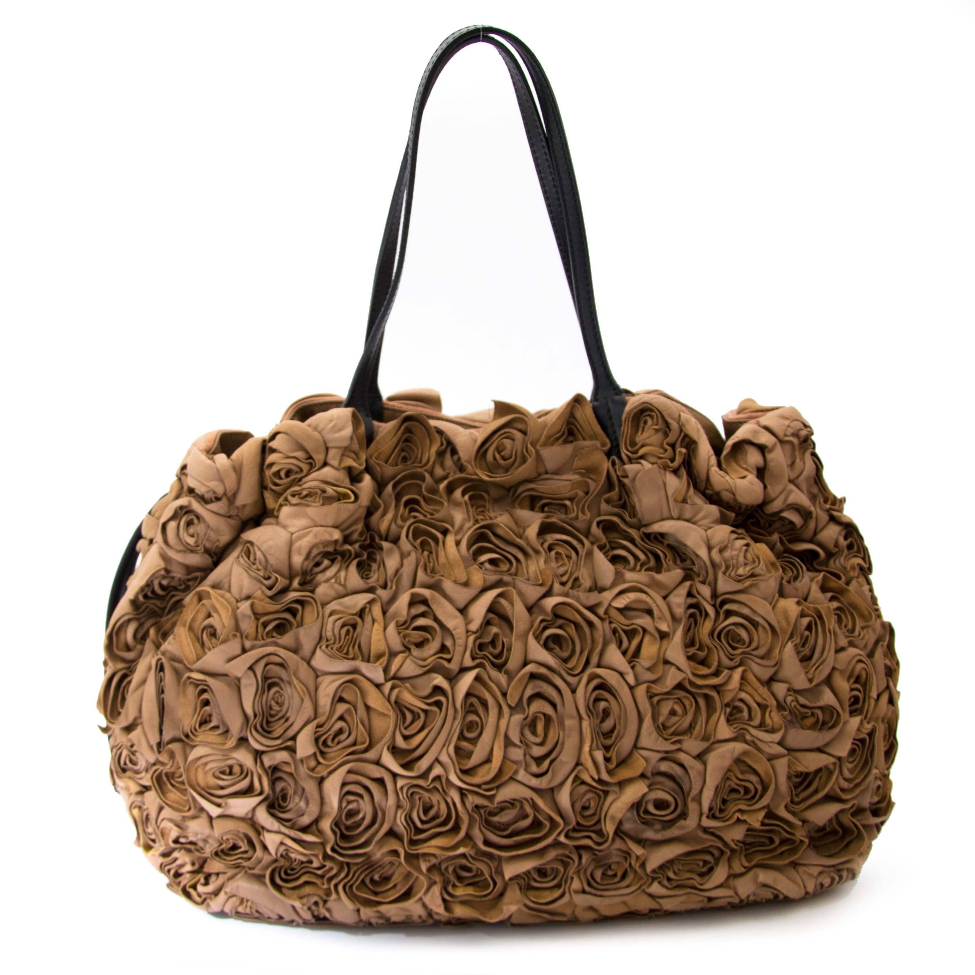 Very good condition

Valentino Taupe Leather Floral Rosette Oversized Bag

This distinctive shoulder bag features all over leathe rosette applications and contrasting black leather shoulder straps.

Gold toned logo placque on the front.

Comes