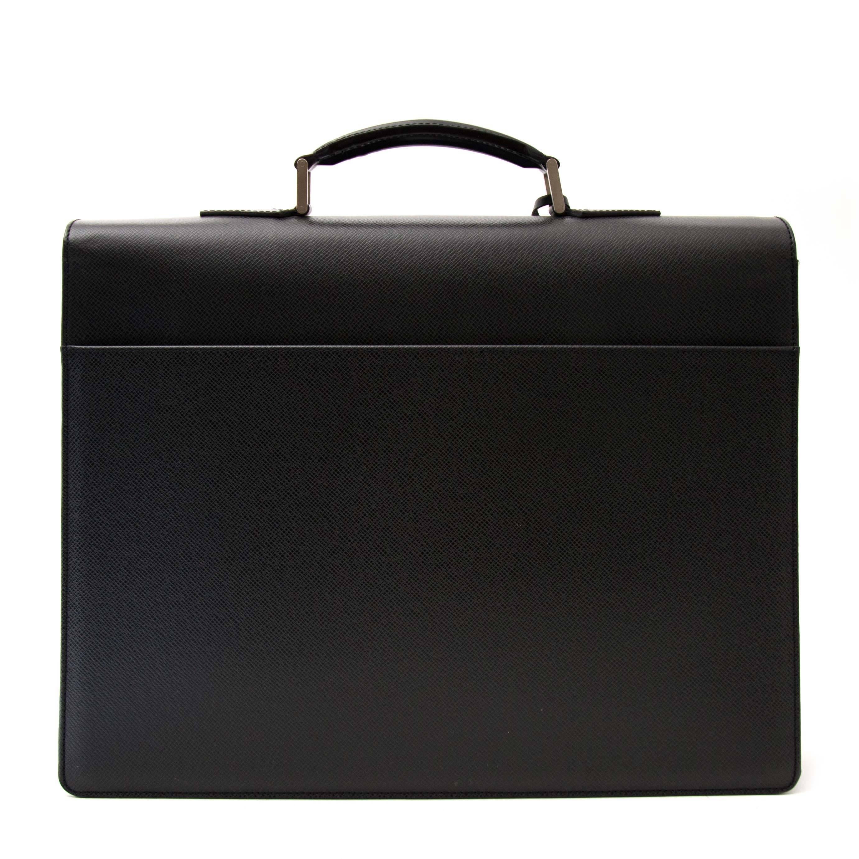 The perfect briefcase for the man who has it all! This Louis Vuitton Briefcase Associé is crafted from durable Taïga leather, a sturdy leather type with structure and relief. 

The bag features silver-toned hardware. The interior holds room for