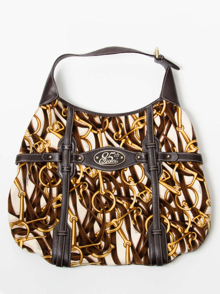 Gucci horse bit print shoulder bag with gold and brown hues. Soft fabric. Features the distinctive silver horse bit at one side, and a tag with 