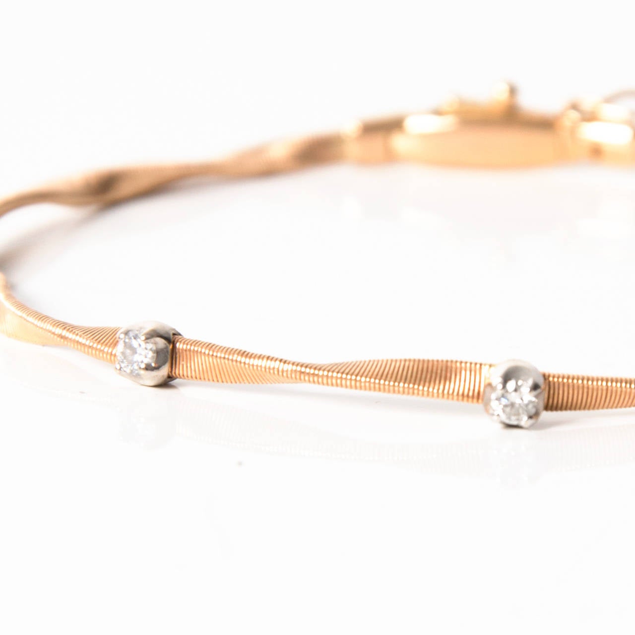 Stunning handcrafted twisted bracelet with three diamonds in 18K yellow gold. Tongue and groove closure.

With fashionable lucidity, this gorgeous bracelet is part of the Marco Bicego Marrakech collection. By hand hammering the gold into a ribbon