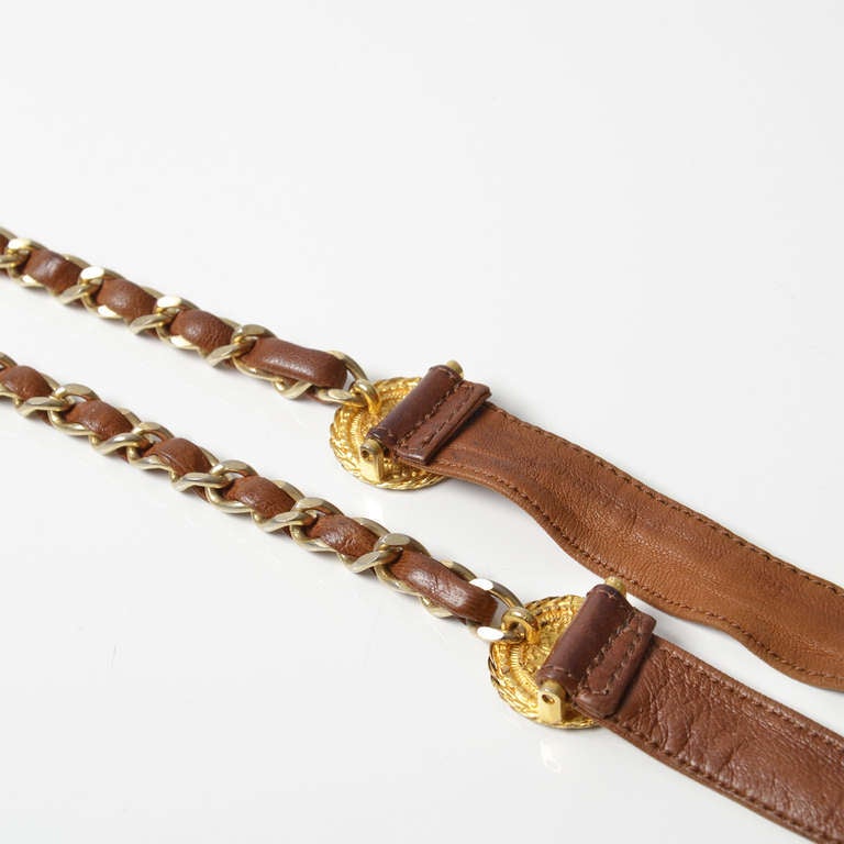 Chanel gold chain and brown leather belt. Features two buttons with the CC logo.