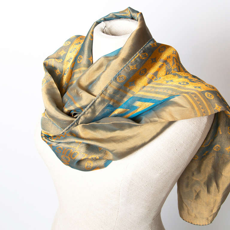 Louis Vuitton blue and gold Mousseline Silk scarf seethrough. Has a monogram print on some parts.