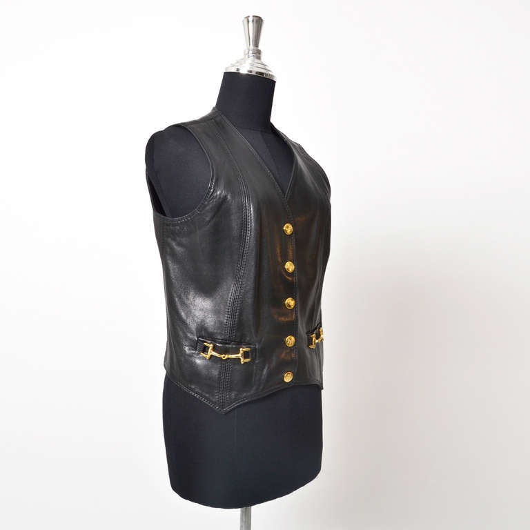 Céline Black Leather Sleeveless Vest with gold Celine logo buttons and gold buckle detail on pockets. Small snit in the back.