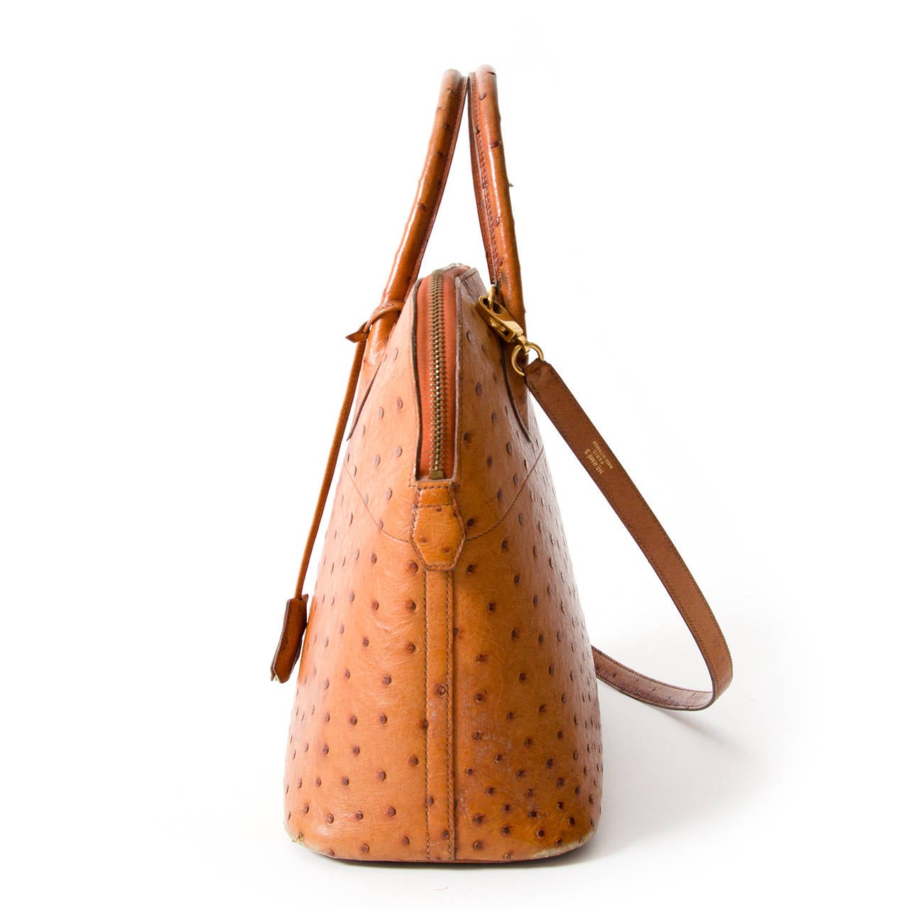 The Hermès Bolide in cognac ostrich leather is a classic bag, which unquestionably embodies femininity and class. It is a domed top handle bag with a zip around closure. The gold hardware adds a luxurious feel to this stunning piece. The interior