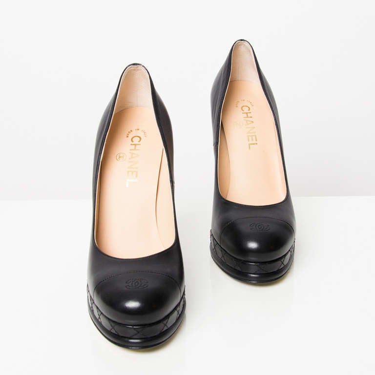 Chanel black leather platform pumps. Gold and black printed sole. Features the double C logo at the front.

Size 40.

Heel measures 12,5 cm.
Platform measures 2 cm.