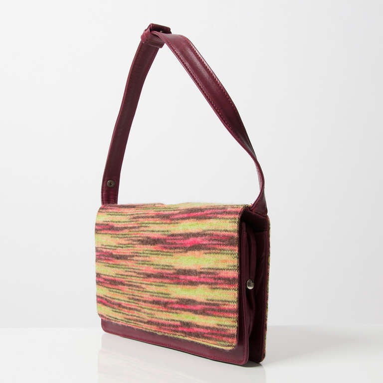 Missoni burgundy red leather shoulder bag with multicolor wool front and back. Adjustable strap which makes it possible to wear the bag as a handbag. Magnetic snap closure. The interior features two open compartments a separate compartment with
