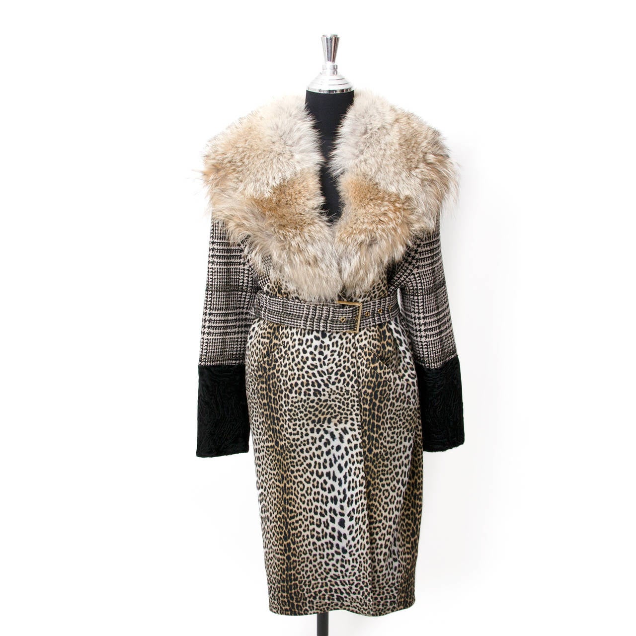 A mid-long furcoat with fox collar. The coat's top is tweed with a classic pattern. The bottom hald is nylon with leopard print. The sleeves have astrakhan cuffs. Comes with belt, to be worn as an opluent trench. Great contemporary style!