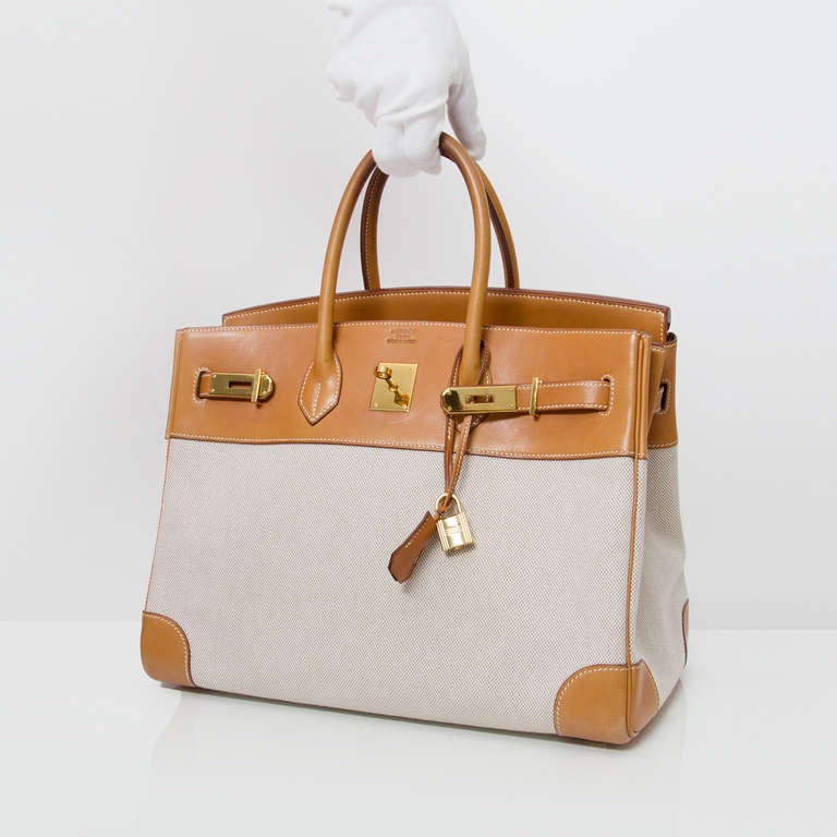 Rare Hermès Birkin bag in sand colored toile and gold Barenia leather. 
Gold hardware. 
Blind stamp 'C' in a square. 

Comes with clochette cadenas and original Hermès dustbag. 

The leather has a smooth, a bit glossy appearance, and is