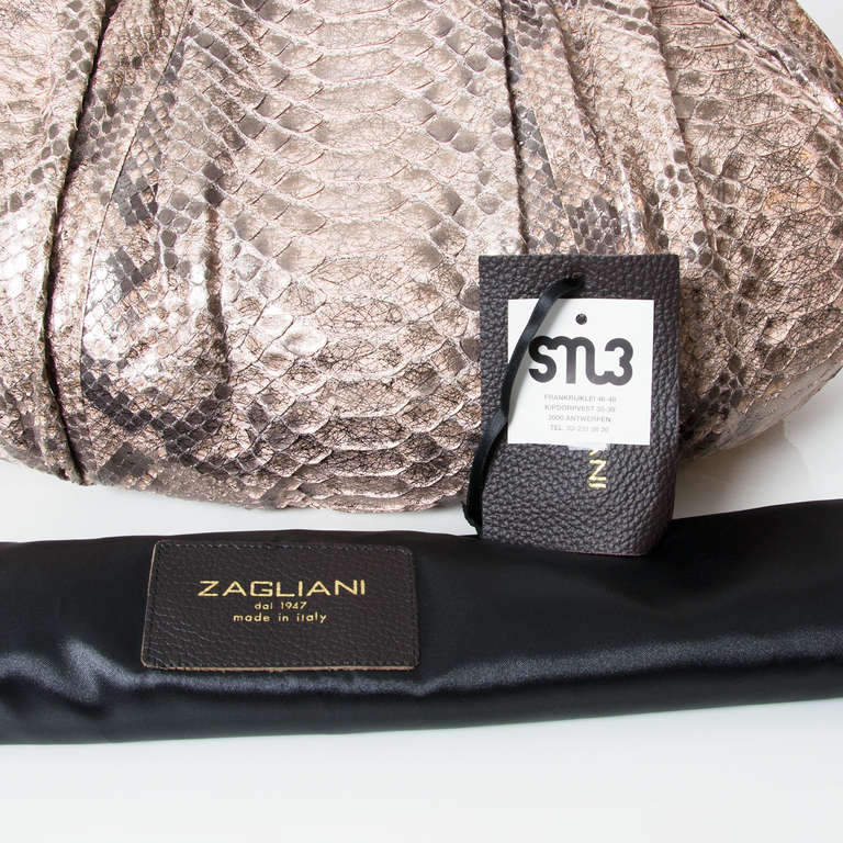 Zagliani’s iconic design, the Puffy by Zagliani, takes on new refinement for spring in old rose metallic python. Signature delicate pleats and a curved handle infuse feminine allure into the voluminous shape that can carry all the day’s
