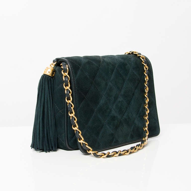 Chanel dark green suede flap shoulder bag with large tassel. Gold hardware throughout. Gold chain and leather strap.

Features the Chanel 