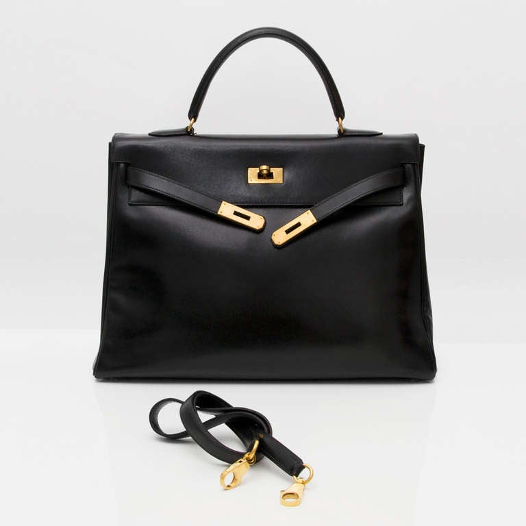 Reach ultimate style and class with this gorgeous authentic Hermès Kelly bag. Executed in pitch black boxcalf leather. Smooth and slightly glossy surface. 
Yellow gold-tone hardware.

Comes with attachable boxcalf shoulder strap. 

Blind stamp: