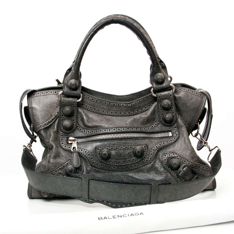 Balenciaga City bag with attachable shoulder strap. 
The leather is decorated with brogueing. 
Giant Covered Hardware. 
Color: Grey 

37 cm

Comes with pocket mirror and original dustbag.