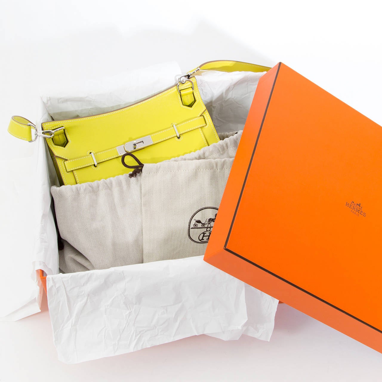 This is an authentic Hermès Swift Jypsiere Gypsy 28 . The Jypsiere is finely crafted of smooth swift calfskin leather in bold lime yellow as well as the stylish shoulder strap that can be removed. The bag features a cross body adjustable strap with