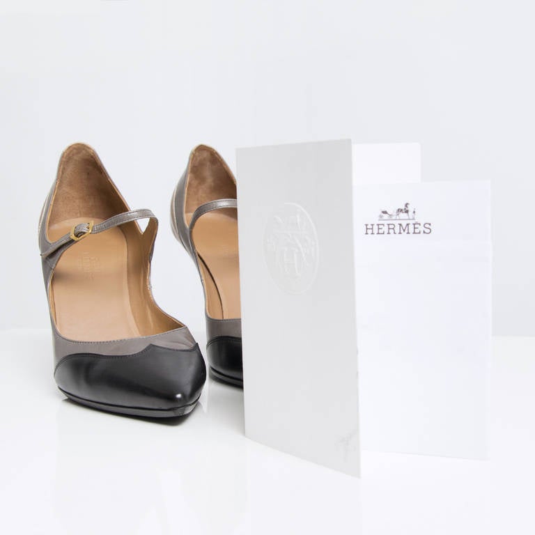 Hermès Escarpin Deesse black, grey and beige pumps. Small matte gold buckle at the strap.

Comes with the original shoe bags and proof of purchase.

Size 37

Heels measure 9 cm.