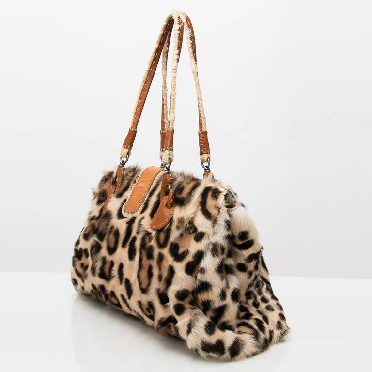Ermanno Scervino Leopard handbag. The luxurious Tianjin fur enhance its feminine quality. The flap closes with a magnet.