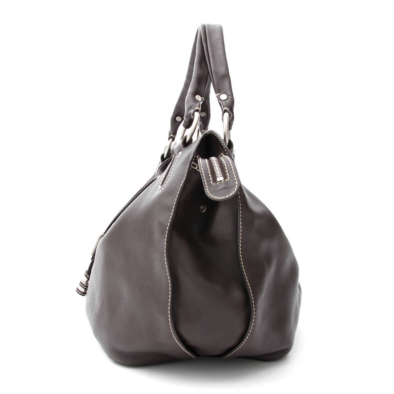 A divine dark brown leather bag with sleek detailing. This Bag is made of beautifully soft & smooth dark brown leather with silver tone hardware, ringed shoulder straps & contrasting off-white stitching throughout the bag. Features a zip closure & a