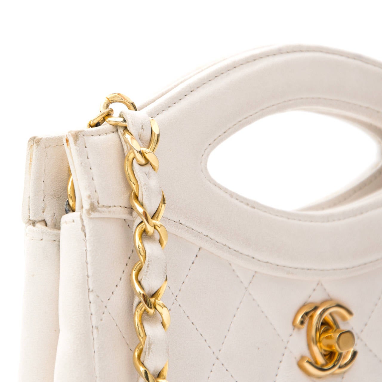 Chanel cream colored lambskin evening top handle clutch on a gold-tone chain. Classic Chanel turnlock and entwined leather and chain shoulder strap.