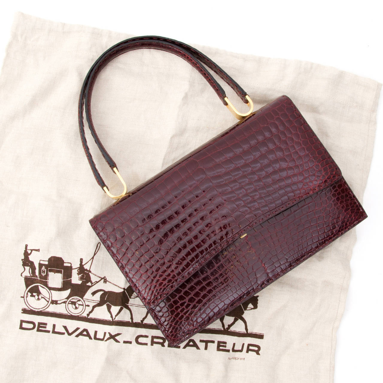 Gorgeous and elegant Delvaux bag made from shiny crocodile hide in rich burgundy hue. This beauty features a gold plated hardware throughout.