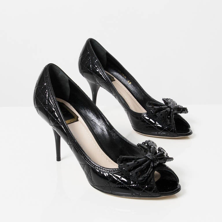 Featuring Christian Dior’s signature touches, these Patent Cannage Leather Bow Pumps will give your look a charming finish. These pumps are made from glossy wuilted patent leather with contrasting stitched trim, bow details with cutouts on the open