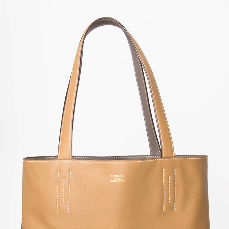 Hermès Double Sens

Length: 36 

Leather: Calfskin / Veau 'Sikkim'

Two-tone double sided tote bag: 'gris souris grey & 'biscuit' beige

Comes with original receipts of purchase, dustbag and box.