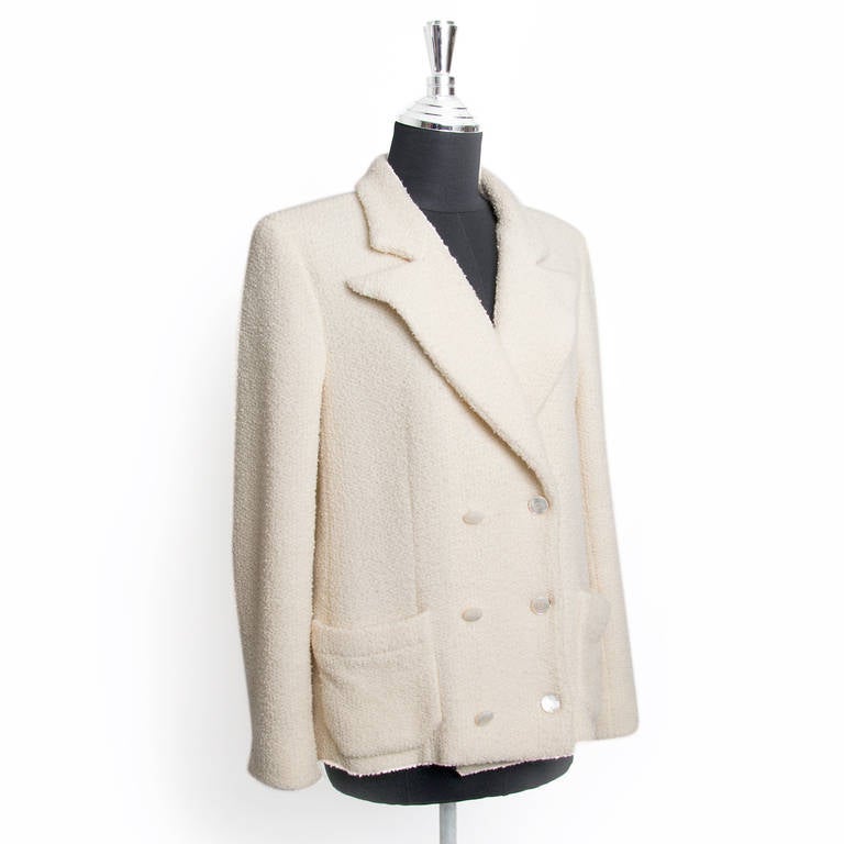 As Karl Lagerfeld has said, “Some things never go out of fashion” Chanel Cream Bouclé Wool Blazer is a must have fashion investment. 
Features a double breasted front with 6 mother of pearl shank buttons with CC logo.