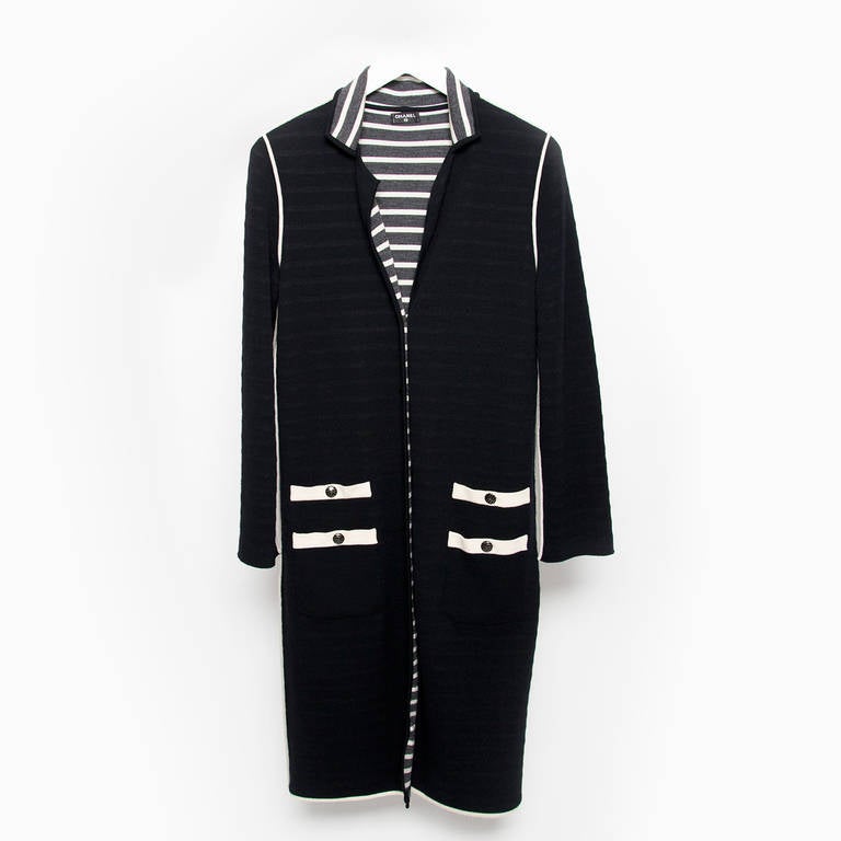 Chanel Dark Blue wool blend cardigan featuring a v-neck, front button closure, 4 front patch pockets , and long sleeves.
Other side blue and white striped and 4 front patch pockets , and long sleeves.