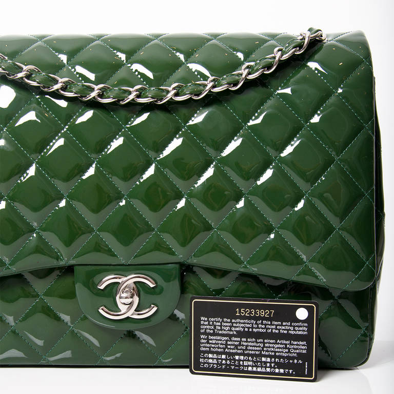 Chanel Green Quilted Patent Maxi Flap Bag is a timeless classic.
Dark green patent leather with Chanel's signature quilted design. A more structured shape with an oversized single jumbo flap. Shiny silver hardware with 