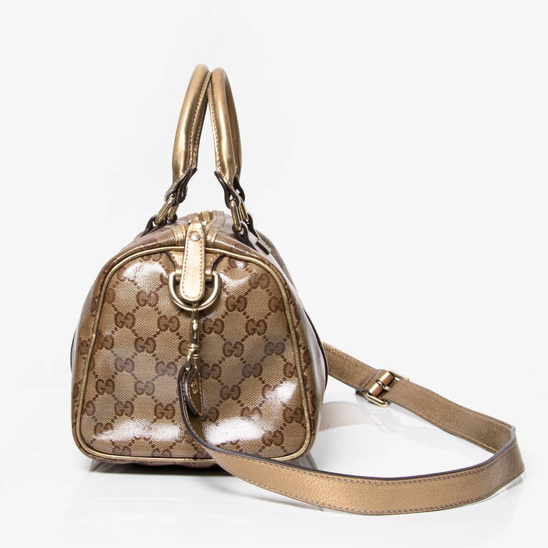 Champagne color GG imprime with gold color leather trim with light gold hardware. 
Comes with authenticity card. 
Zip-top closure 
Shoulder strap 
Embossed gucci trademark leather tab 
Interior pocket