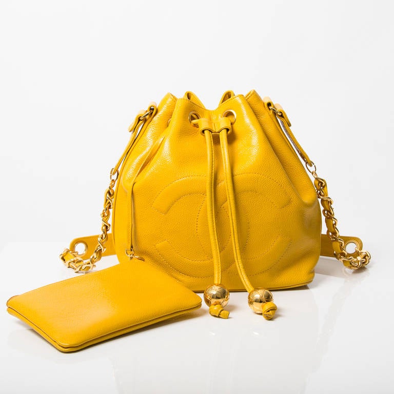 The bucket bag is back! Go for this 90s Chanel piece in fun yellow caviar leather with gold-tone hardware. 

Hologram sticker, Chanel R in a circle and 'made in Italy' gold stamped.