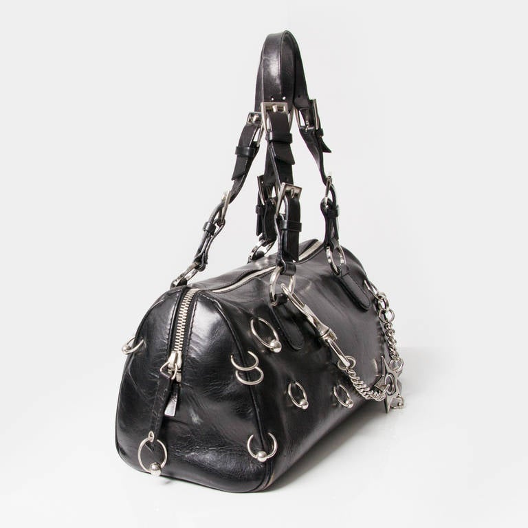 The Dior Hardcore Pierced Boston is a true cohesion of striking and classic elements. Polished leather is boldly contrasted with piercings, as the handles feature multiple buckles. This is the perfect piece for adding a fierce edge to your handbag