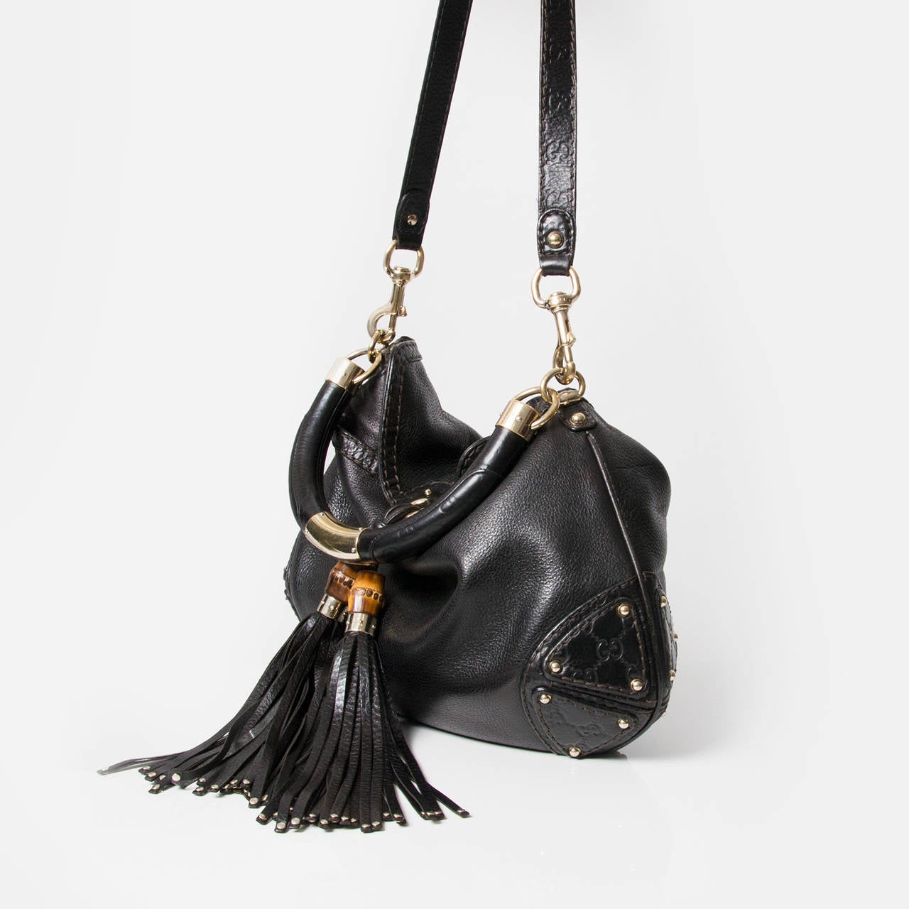 Gorgeous Gucci Hobo bag in black grained calfskin with a wooden arched handle, covered with black leather and two bamboo & leather tassels. 
Including an attachable shoulder strap. 
Comes in original dustbag and with receipt of purchase.