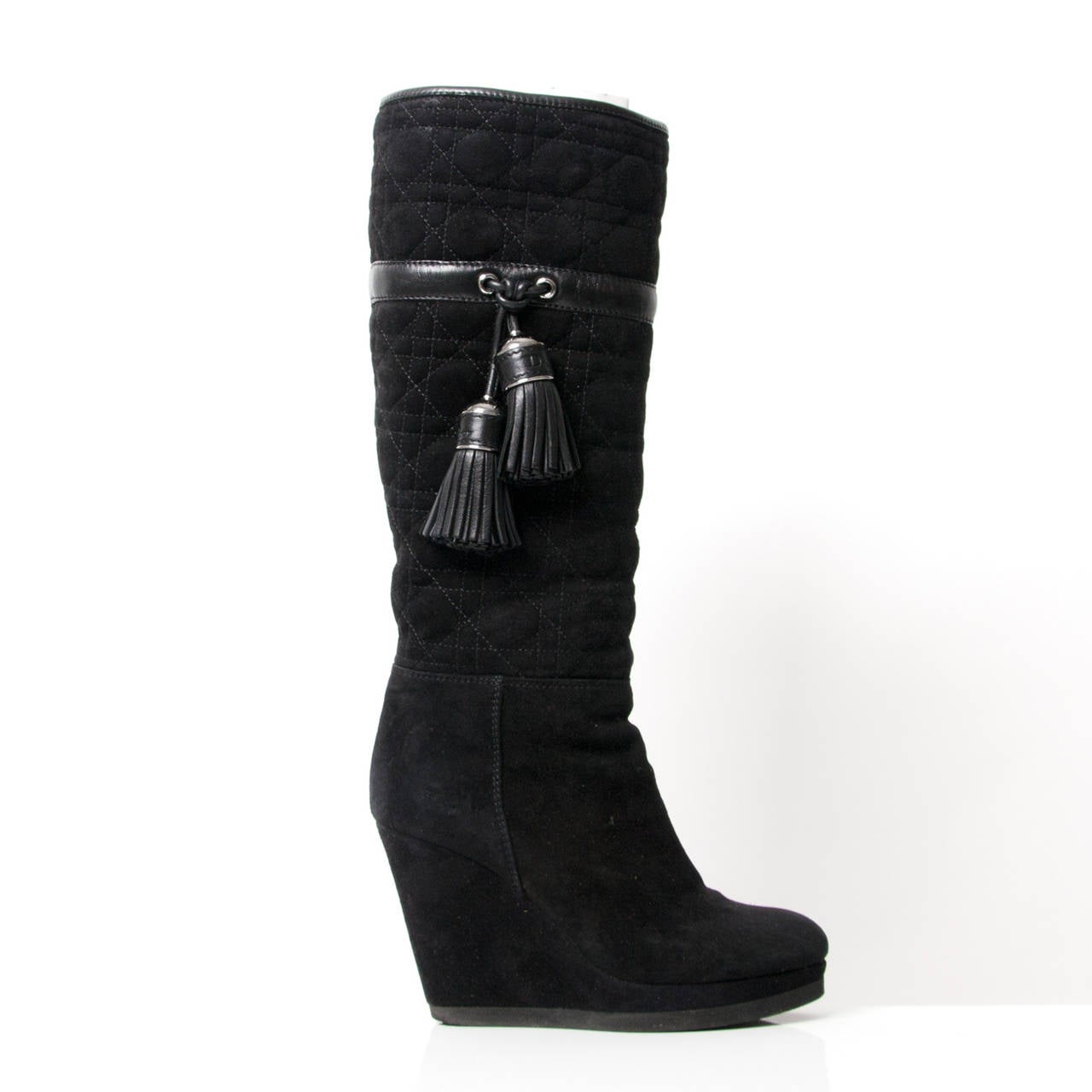 There is no better way to dress up your feet than with a fabulous pair of Christian Dior boots. 
Color: Black quilted cannage suede upper. 
Dyed shearling lining.
Silvertone capped leather pom tassels down side.