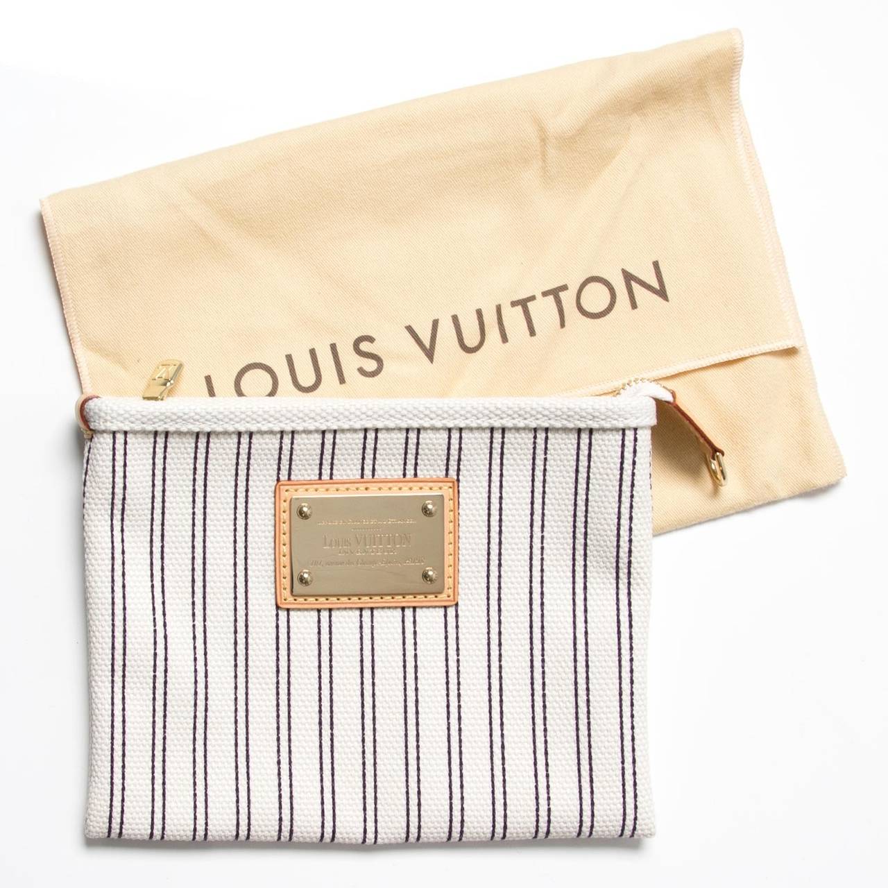 Cute Louis Vuitton zipper pochette in white canvas or 'Toile Antigua', with shiny gold details. 
Comes with original serial code tag 'M40130' and 'Toile Antigua' booklet. 
Comes in its original dustbag.