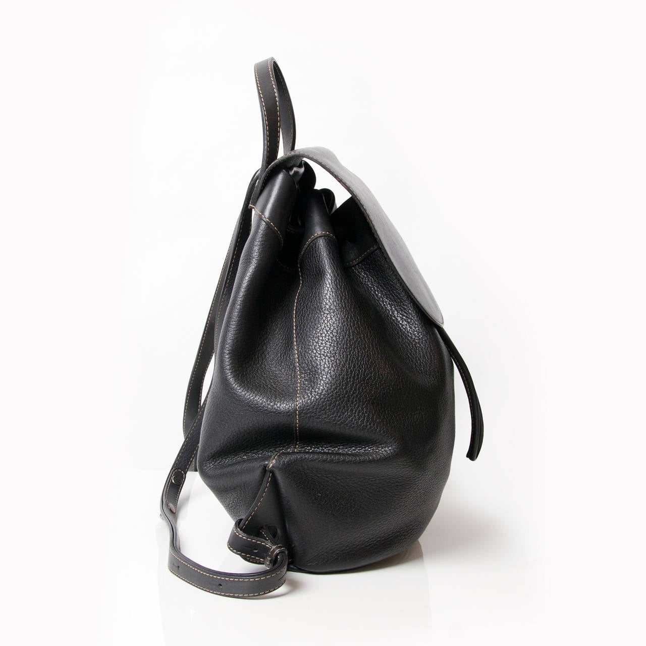 Deux de Delvaux black backpack with silver hardware. Strap closure.
Adjustable shoulder straps.