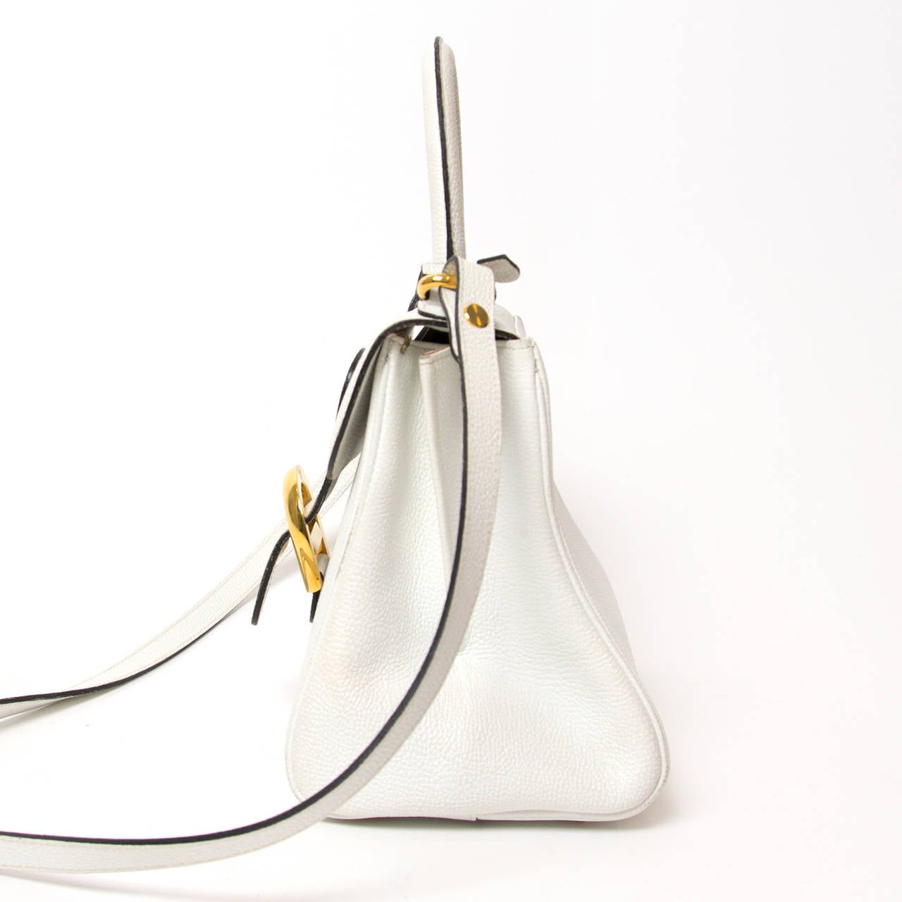 This Delvaux Brillant PM bag is a white grained calfskin top handle bag with attachable shoulder strap.